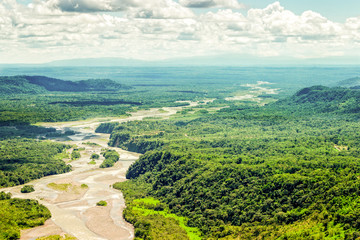 A breathtaking aerial view of the Amazon rainforest in Ecuador, showcasing the lush green canopy, meandering river, and diverse ecosystems.