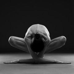 Obrazy na Plexi  Naga joga. Piękne seksowne ciało młodej kobiety na czarnym tle