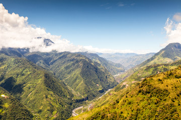 A breathtaking aerial view of Ecuador's Amazon rainforest in Llanganates National Park, showcasing lush green canopy, winding river, and majestic valley.