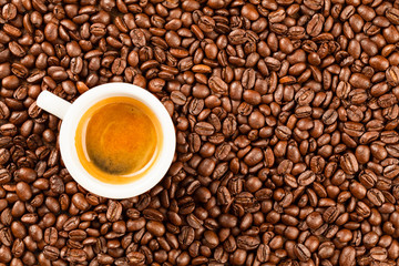 A small espresso cup set against a backdrop of aromatic roasted coffee beans offering a captivating tableau that stimulates both academic curiosity and sensory delight