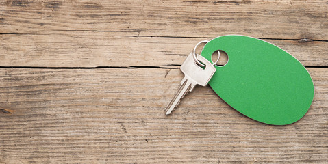 key with a blank label on an old wooden plank