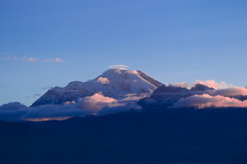 Experience the breathtaking beauty of Chimborazo volcano in Ecuador as the sun sets,creating a mesmerizing and unforgettable sight.