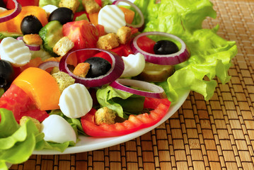 Греческий салат на белой тарелке