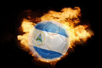 Fototapeta premium football ball with the flag of nicaragua on fire