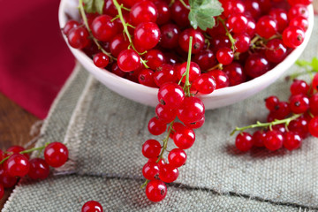 Fresh red currants in bowl on table close up