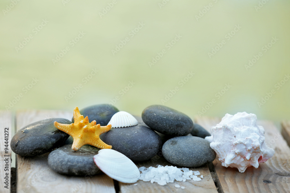 Poster Composition of pebbles and shells on wooden background