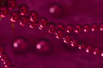 Christmas pink garland made from small  beads.On A rosy Background. New year toy. Toned