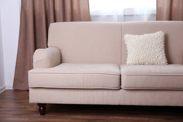 Comfortable sofa with pillows in the room, close up