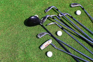 Different golf clubs  and balls on golf course