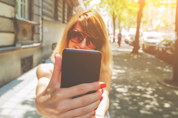 Urban girl doing selfie in a classic European street surroundings.