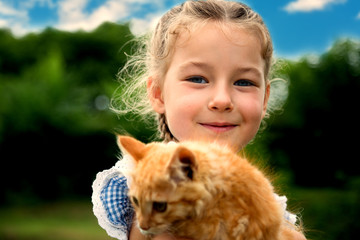 Cute little girl playing with a kitten. Apply with a retro vintage instagram filter app or action.