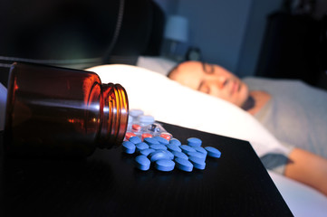 pills and young man in bed