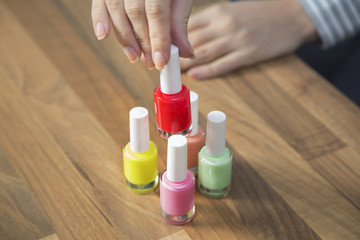Woman holding red nail polish.