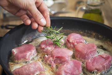 Preparing filet mignon with rosemary.