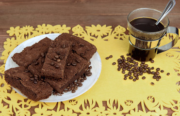 On a wooden table on yellow napkin glass cup of coffee with