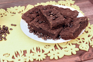 On a wooden table on yellow  plate of chocolate truffle cake