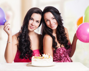 Obraz na płótnie Canvas Two happy young women with cake