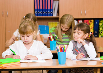 Schoolgirl cheating at exam, looking at a friend's writing