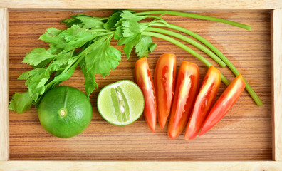 Celery, tomatoes, lemon on the wooden floor
