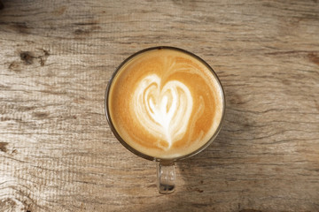 cup of latte art coffee on wooden background