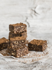 chocolate fudge with cookies and nuts on a light wooden surface