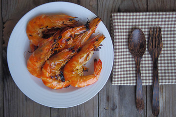 Grilled shrimp arranged on white plate with spoon