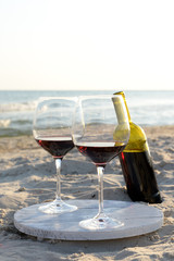 Wine bottle and glasses on the seashore