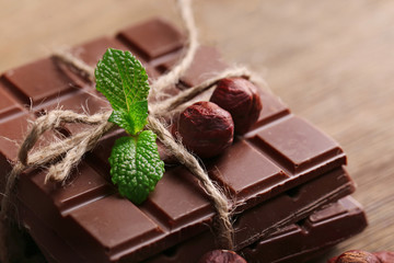 Black chocolate pieces with nuts on wooden background
