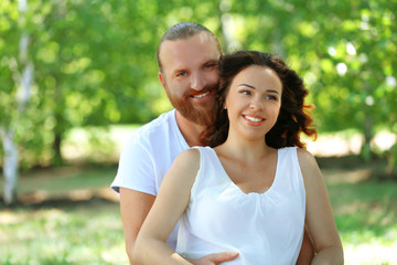 Fototapeta premium Portrait of embracing couple in the park, close up