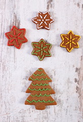 Fresh baked decorated gingerbread on old wooden background, christmas time