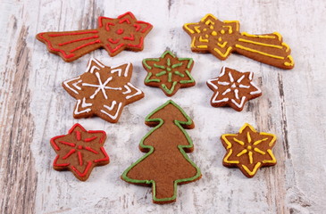 Fresh baked decorated gingerbread on old wooden background, christmas time