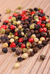 Heap of fresh colored pepper on wooden background