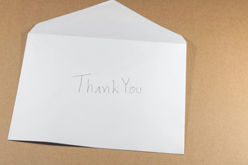 wording thank you of white envelope on brown background