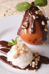 Pear in chocolate with nuts and vanilla ice cream close-up. vertical
