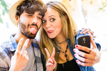 Fototapeta premium Funny Selfie, Couple of Hipsters Having Fun with Smartphone Phot