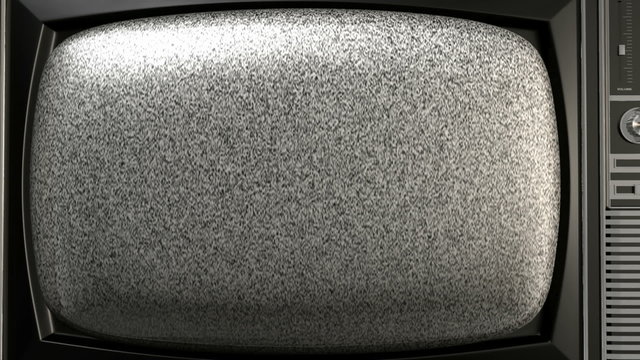 A zoom out from the screen of a vintage wood plastic and chrome television that are displaying a static snowy pattern