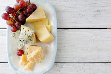 cheeses and red grapes on plate