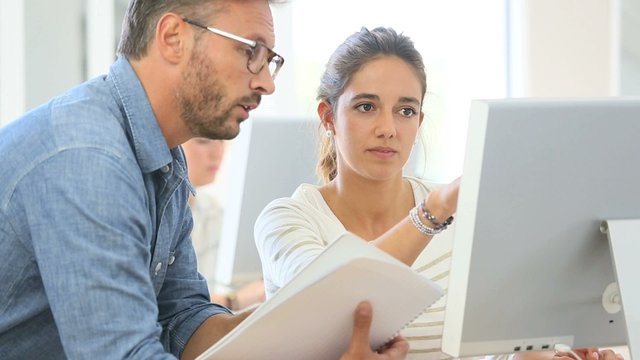 Teacher with student working on computer