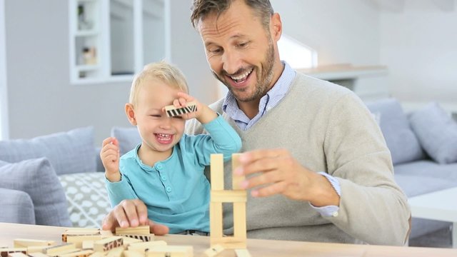 Daddy with 2-year-old boy playing with wooden blocks