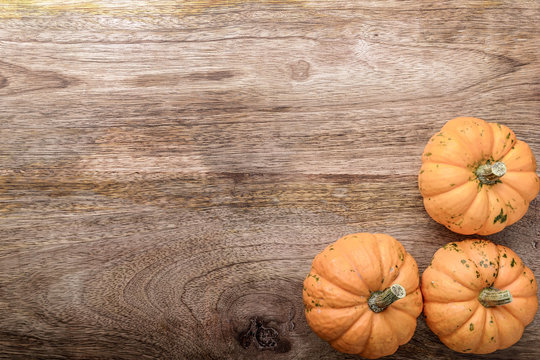 three small pumpkin on wooden background