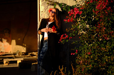 Girl model with a beautiful flower in her hair and sunny glow.