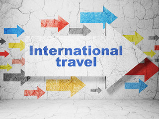 Tourism concept: arrow with International Travel on grunge wall background