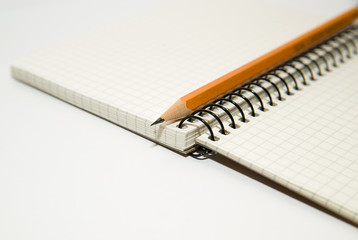 Opened notebook and pencil on over white