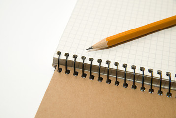 Opened notebook and pencil on over white