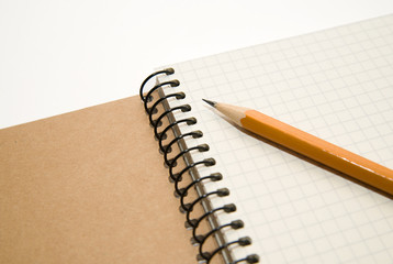 Opened notebook and pencil on over white