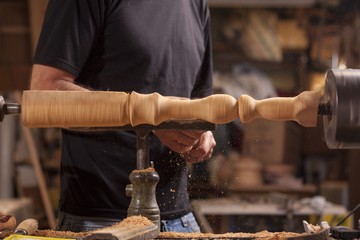 worker turning wood on a lathe