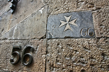 Maltese Cross and house number on the wall