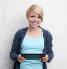 Attractive teenage girl using tablet device