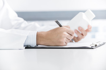 Close-up Of Male Doctor Filling The Medical Form