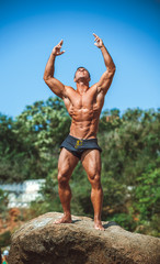 Man Athlete on a rock by the sea against the sky